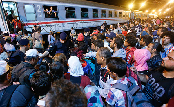 Refugiados tratando de subir al tren en Budapest