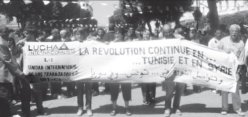 Delegaci�n de Lucha Internacionalista y de la UIT-CI en la movilizaci�n de trabajadores tunecinos del 1� de Mayo, en la capital de T�nez, luego de realizada la reuni�n de Regued, en apoyo a la lucha del pueblo sirio. La pancarta dice �La revoluci�n sigue en T�nez y en Siria� (en frances y �rabe). De izquierda a derecha Pepe D�az, Cristina Mas, Marga Olalla, Pablo Medina (de Lucha Internacionalista del estado Espa�ol), y Miguel Sorans, de la Unidad Internacional de los Trabajadores (UIT-CI)-.